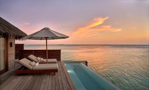 a resort with a swimming pool and an umbrella at Conrad Maldives Rangali Island in Mandhoo