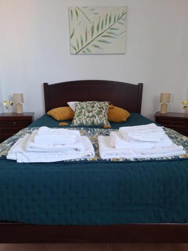 a bed with three towels on top of it at Apartamento Bela Vista Ilha Terceira in Feteira