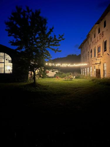 un bâtiment avec un arbre et une table dans la cour dans l'établissement Fabrique des Luddites - chambres et gîte, à Chatte