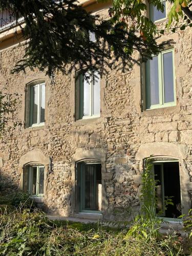 - un vieux bâtiment en pierre avec des fenêtres et un arbre dans l'établissement Fabrique des Luddites - chambres et gîte, à Chatte