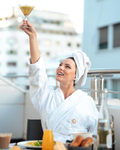 a woman holding up a glass of wine in the air at Oum Palace Hotel & Spa in Casablanca