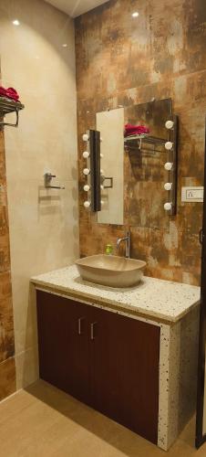 un baño con lavabo y espejo en Mango Villa at ShivarAgrotourism, en Ratnagiri