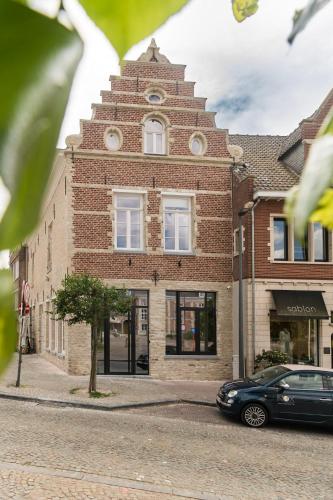 a brick building with a car parked in front of it at NOX Logies, vakantiewoning en polyvalente ruimte in Grimbergen