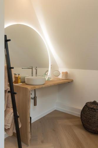 a bathroom with a sink and a mirror on the wall at NOX Logies, vakantiewoning en polyvalente ruimte in Grimbergen