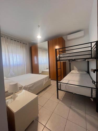 a bedroom with two bunk beds and a desk at Il Cavalluccio Marino in Ladispoli
