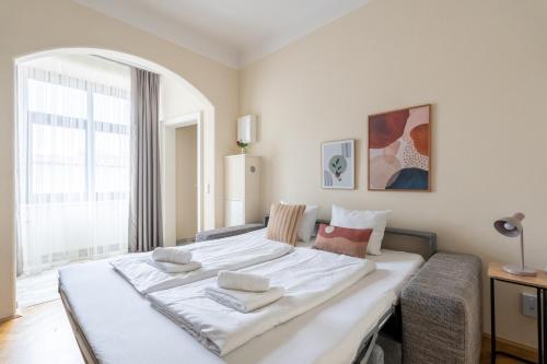 a large white bed in a room with a window at Vienna Stay Apartments Schönbrunn in Vienna