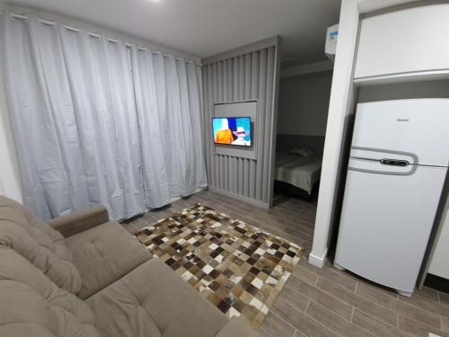 a living room with a couch and a television at LOFT512 Maxplaza Canoas in Canoas