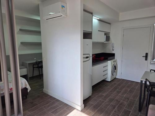 a small kitchen with a white refrigerator and a table at LOFT512 Maxplaza Canoas in Canoas