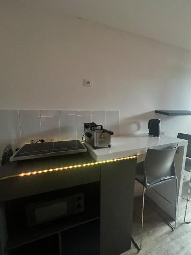 une cuisine avec un comptoir, une cuisinière et des chaises dans l'établissement Jacuzzi suite, à Montfermeil