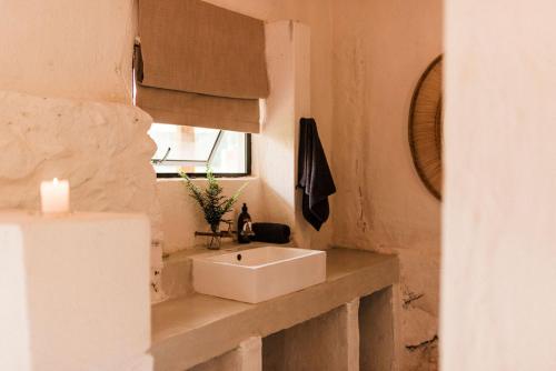 a bathroom with a white sink and a window at Zwakala River Retreat in Haenertsburg