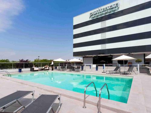 a swimming pool in front of a hotel at Pullman Bordeaux Lac in Bordeaux