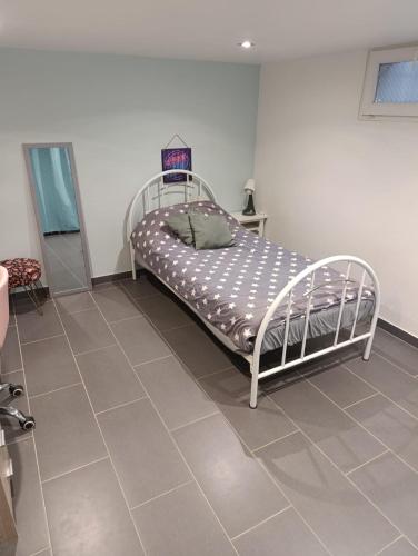 un lit dans une chambre avec un sol carrelé dans l'établissement Vacances comme à la maison, à Arnouville-lès-Gonesse