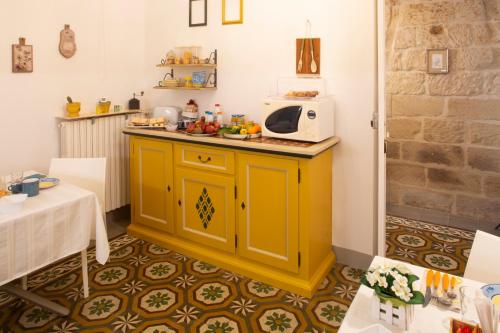 a kitchen with a yellow cabinet and a microwave at Domus Liventa B&B in Cursi