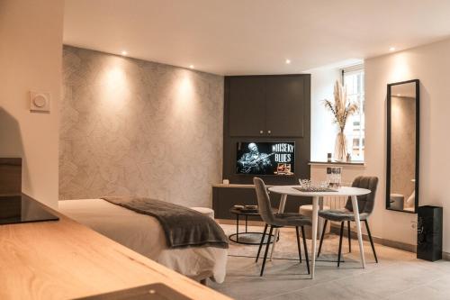 une chambre avec un lit, une table et des chaises dans l'établissement Studio Le Benetin 2 personnes à Dinan, à Dinan