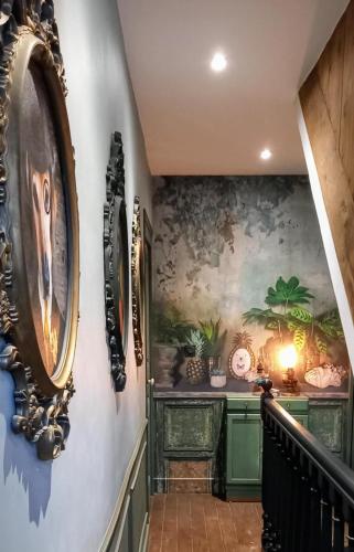 un couloir avec un escalier orné d'une peinture murale. dans l'établissement maison de charme, à La Celle-sous-Gouzon