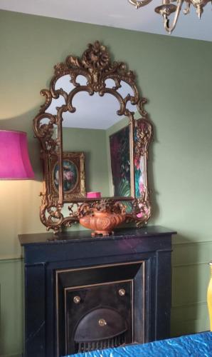 - un miroir au-dessus d'une cheminée dans la chambre dans l'établissement maison de charme, à La Celle-sous-Gouzon