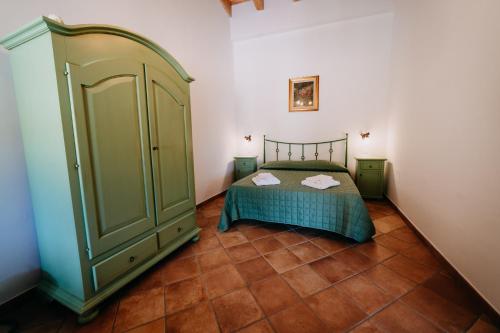 a bedroom with a bed and a green cabinet at Tenuta Le Tre Rose in Vibonati
