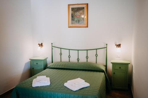 a bedroom with a green bed with two green cabinets at Tenuta Le Tre Rose in Vibonati