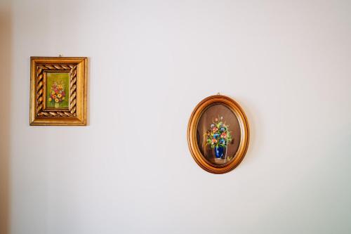 two framed paintings hanging on a white wall at Tenuta Le Tre Rose in Vibonati