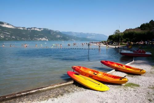 three kayaks sitting on the shore of a beach at Le Portougais, Chalet À Chanaz in Chanaz