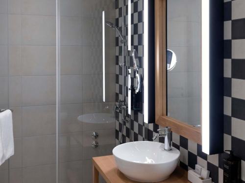 a bathroom with a white sink and a mirror at Mercure Belgrade Excelsior in Belgrade