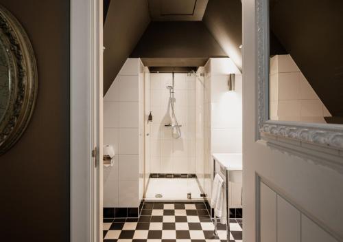 a bathroom with a shower with a checkered floor at Landgoed Huize Bergen Den Bosch - Vught in Den Bosch