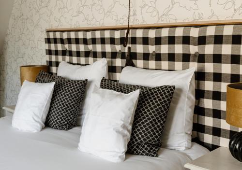 a pile of pillows sitting on top of a bed at Landgoed Huize Bergen Den Bosch - Vught in Den Bosch