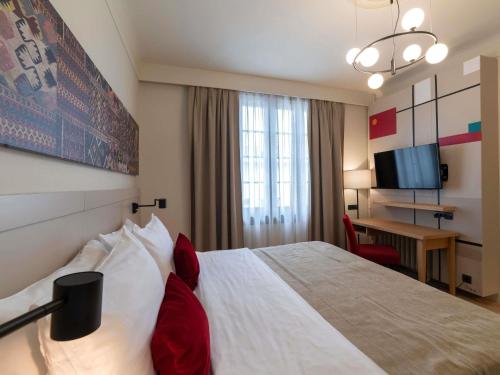 a hotel room with a bed and a desk at Mercure Belgrade Excelsior in Belgrade