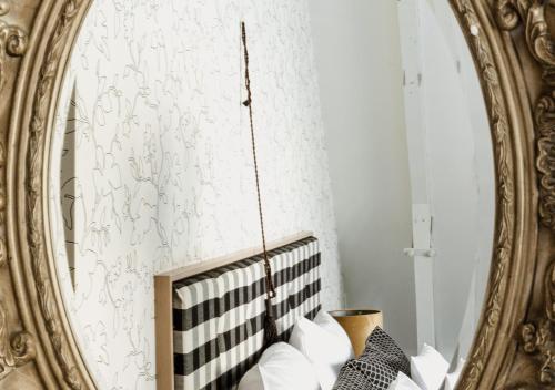 a mirror in a room with white walls and white pillows at Landgoed Huize Bergen Den Bosch - Vught in Den Bosch