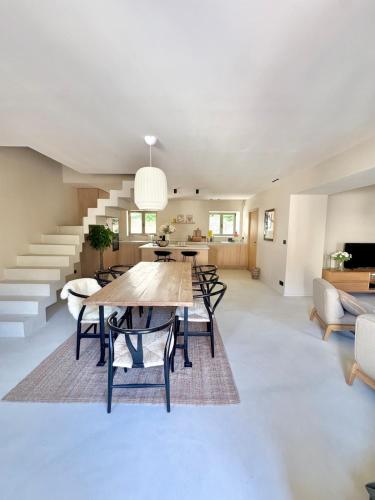 une salle à manger et un salon avec une table et des chaises dans l'établissement Maison de ville piscine chauffée, à Eyragues