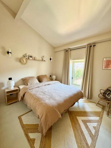 une chambre avec un grand lit et une fenêtre dans l'établissement Maison de ville piscine chauffée, à Eyragues