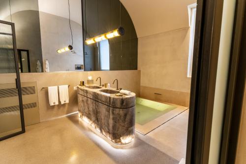 a bathroom with a stone sink and a mirror at Palazzo De Noha - Boutique Hotel in Lecce