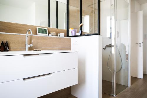 une salle de bain blanche avec un lavabo et une douche dans l'établissement Charmante maison moderne - quartier des Roses - 8 personnes, à La Rudelière