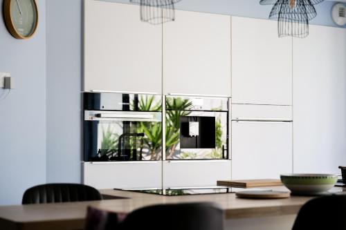 une salle à manger avec une table et un four micro-ondes dans l'établissement Charmante maison moderne - quartier des Roses - 8 personnes, à La Rudelière