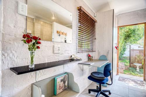 Muthaiga Stays - Studio Venue في ديربان: مطبخ مع مكتب و إناء من الزهور