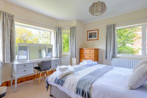 a bedroom with a bed and a desk and a mirror at Finest Retreats - Sea Bank in Colwyn Bay