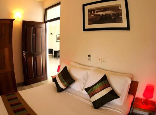 a bedroom with a white bed with two pillows at The Villa In Lavinia in Mount Lavinia