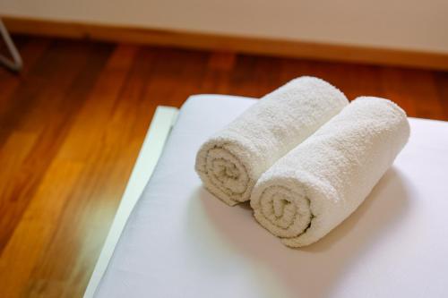 two rolls of white towels sitting on a table at Ponta do Sol Amazing 3 Bedroom Apartment in Ponta do Sol