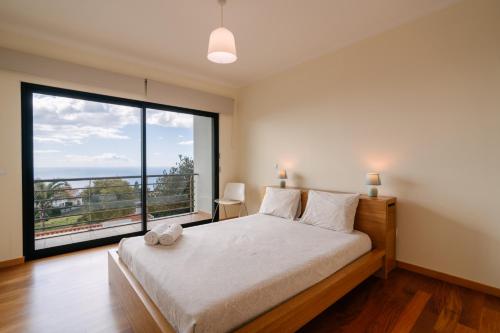 a bedroom with a bed and a large window at Ponta do Sol Amazing 3 Bedroom Apartment in Ponta do Sol