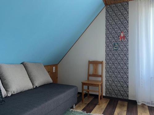 a bedroom with a bed and a chair next to a staircase at Aare kodumajutus in Tammiku
