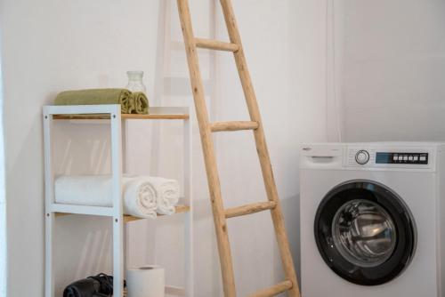 a ladder shelf next to a washing machine at Maggano Paros Apartments 3 in Angairiá