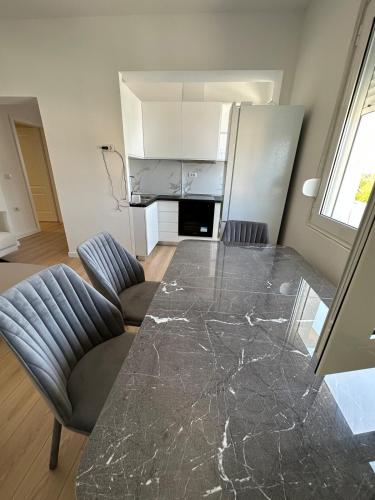 a kitchen with a large marble table and chairs at Appartamento Viliano ! in Orikum