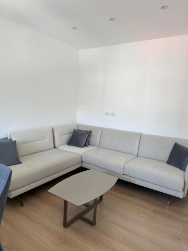 a white couch with blue pillows in a living room at Appartamento Viliano ! in Orikum