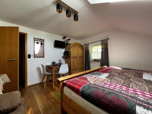 a bedroom with a bed and a desk at Pension Bergliebe in Spiegelau