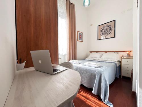 Un dormitorio con una cama y un ordenador portátil sobre una mesa. en DomusVaticano, en Roma