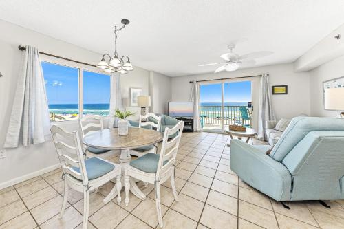 a dining room and living room with a table and chairs at Four Winds 301 in Orange Beach