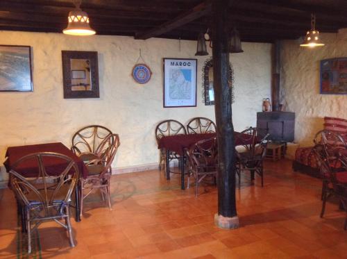 a dining room with tables and chairs and a tv at Caiat Lounge Refuge in Taghzoute