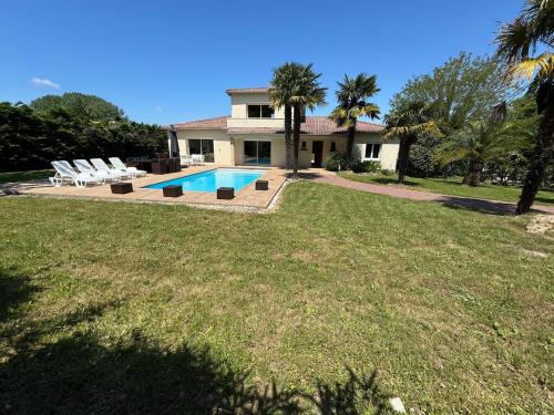 une maison avec une piscine dans une cour dans l'établissement Villa avec piscine, à 5km de la plage, à Saint-Augustin