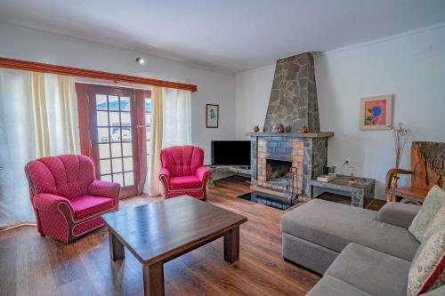 a living room with a couch and chairs and a fireplace at Grace Villa in Terra Chã