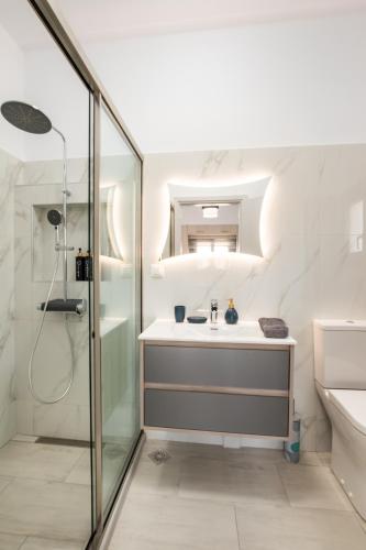 a white bathroom with a shower and a sink at Arkasa Sunset Dream in Arkasa
